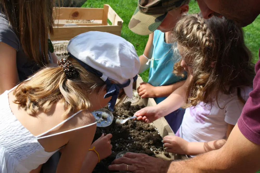 Des enfants observent les escargots à la loupe pendant une visite